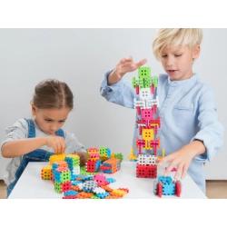Dzieci podczas zabawy przy budowaniu wieży z klocków